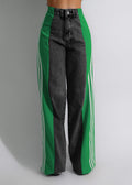 Black jeans with green and white stripes on a gray background