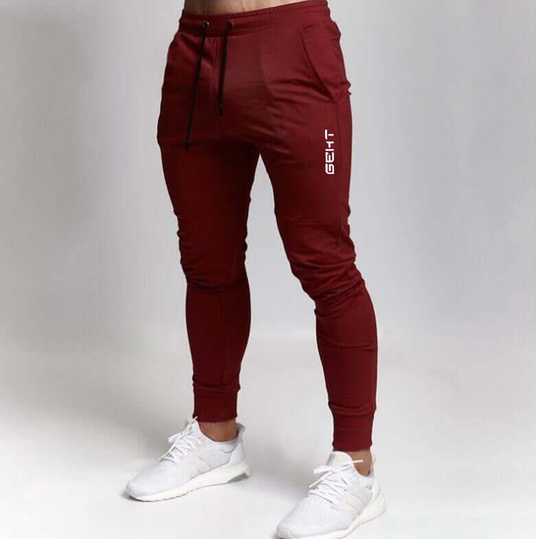 Men’s maroon jogger pants with brand logo on gray background – casual gym or streetwear