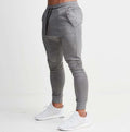 Gray jogger pants worn by a person on a white background