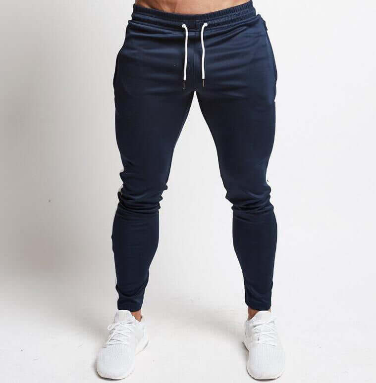 Navy blue jogger pants worn by a person on a white background