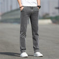 Person wearing gray jeans and white sneakers on a blurred background