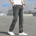 Person wearing gray jeans and white sneakers on a blurred street background