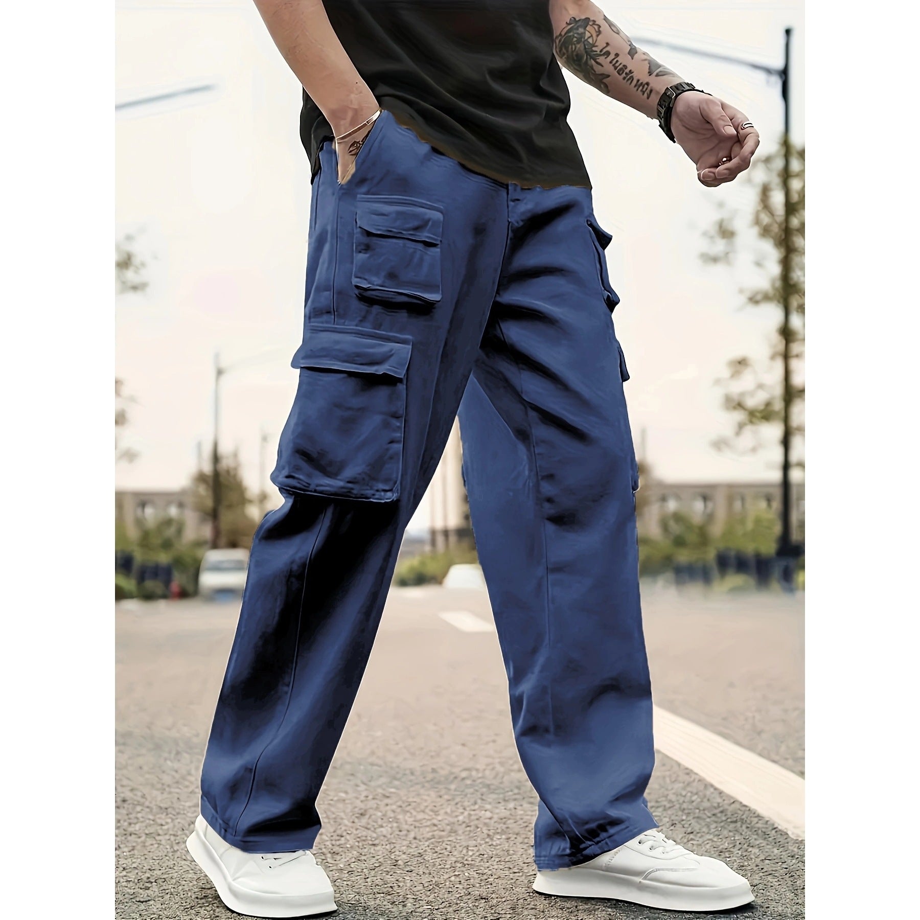 Person wearing blue cargo pants and white sneakers on a blurred street background
