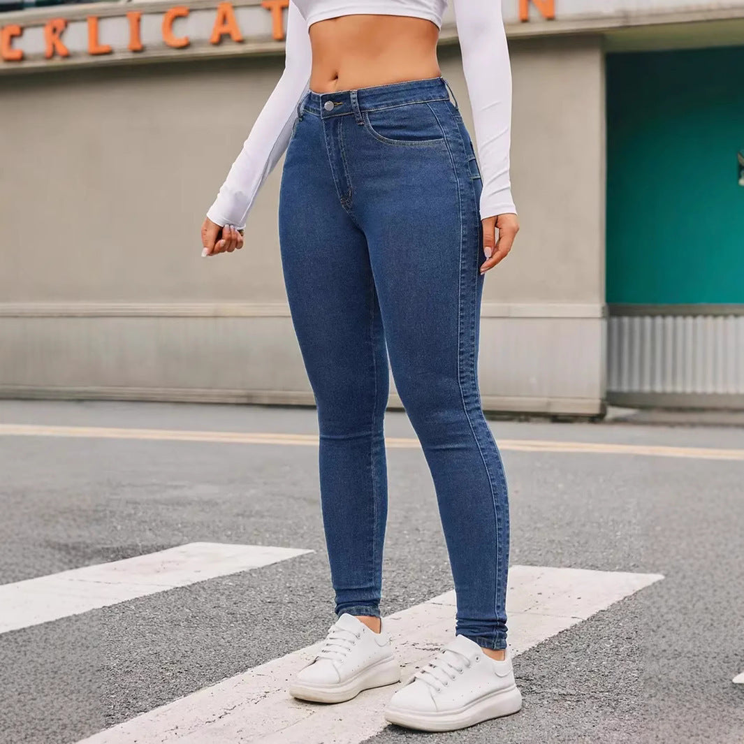 Woman wearing blue skinny stretch denim jeans with white sneakers walking on a street