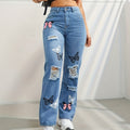 Woman wearing high-waisted straight leg blue jeans with trendy butterfly print .
