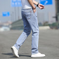 Person wearing light blue jeans and white sneakers on a blurred background