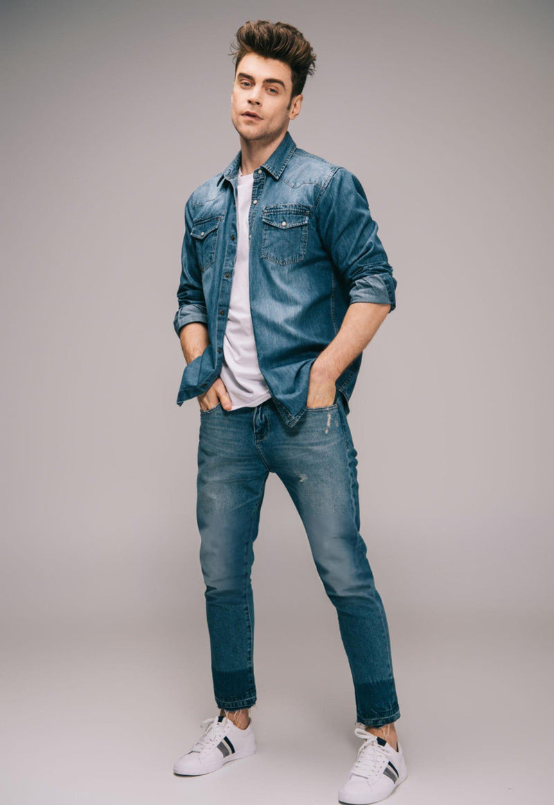 Man wearing a denim shirt and jeans with white sneakers on a gray background - JeansSpot 