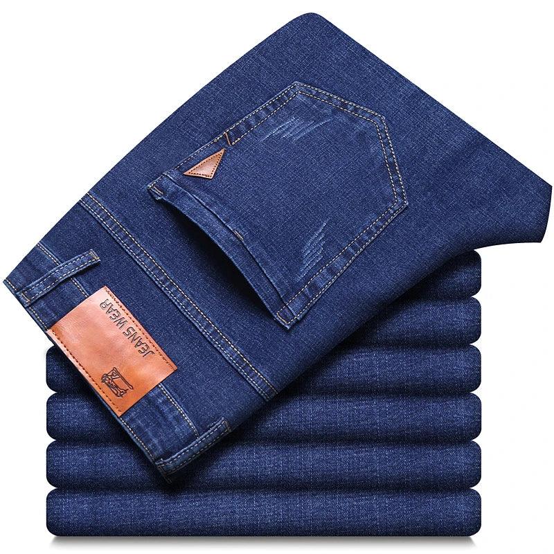 Stack of blue jeans with a brand label on a white background