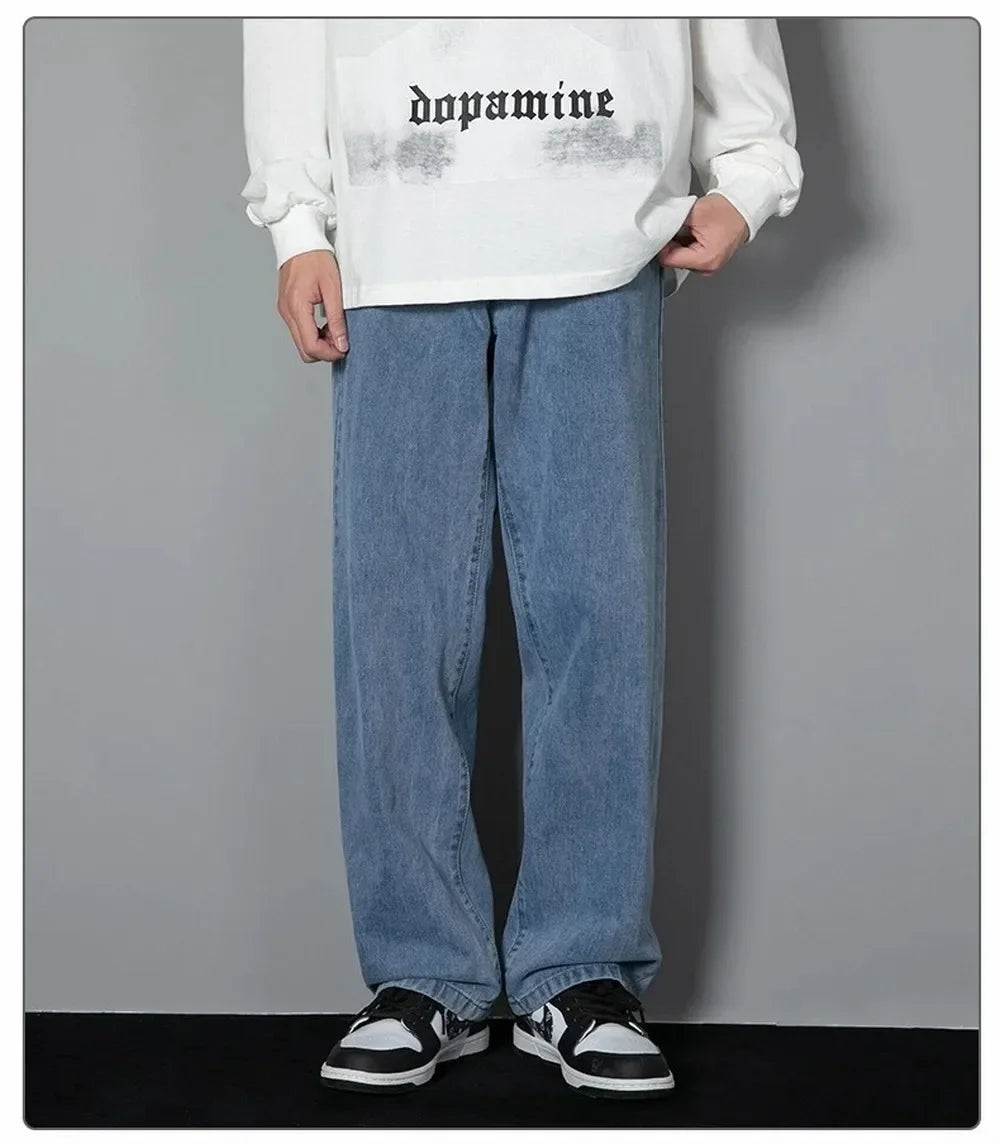 Person wearing a white sweatshirt   blue jeans against a gray background