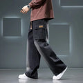 Men’s black cargo pants with wide-leg loose fit worn with white sneakers, streetwear style on a gray background
