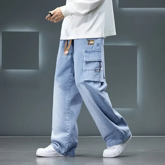 Men’s light blue cargo pants with wide-leg loose fit worn with white sneakers, streetwear style on a gray background