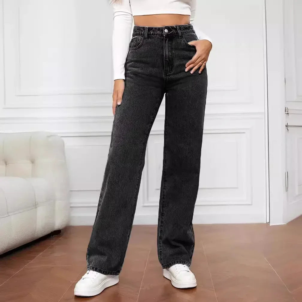 Woman wearing high-waisted retro baggy black jeans standing on a white background