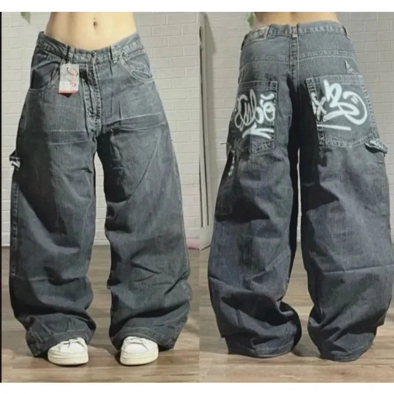 Pair of baggy jeans with branding on a wooden floor.