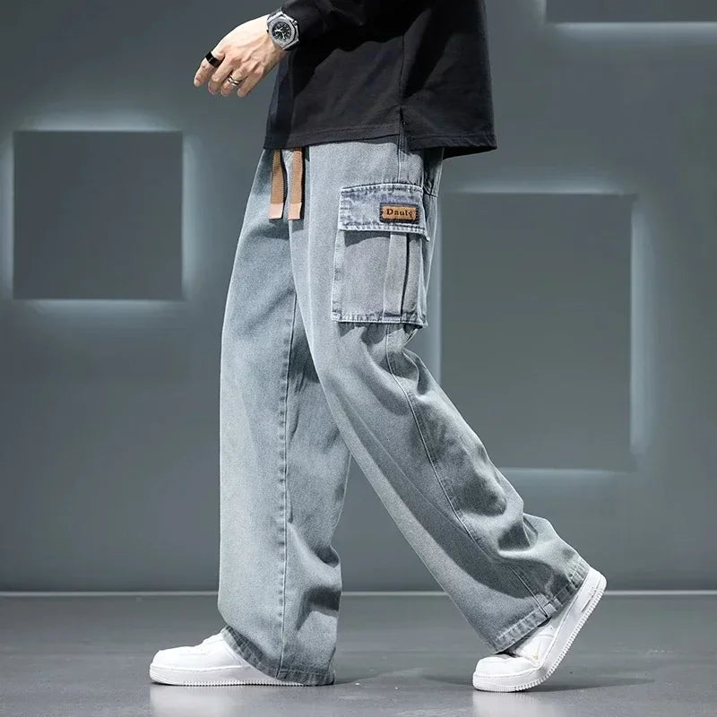 Men’s gray cargo pants with wide-leg loose fit worn with white sneakers, streetwear style on a gray background
