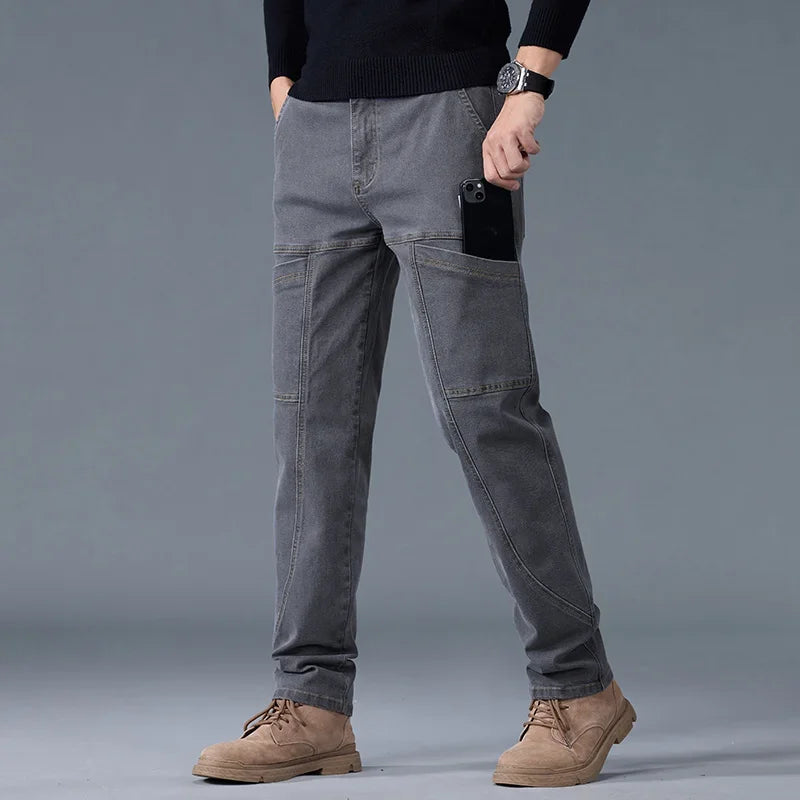 Man wearing gray straight cut cargo pants with six pockets on a gray background