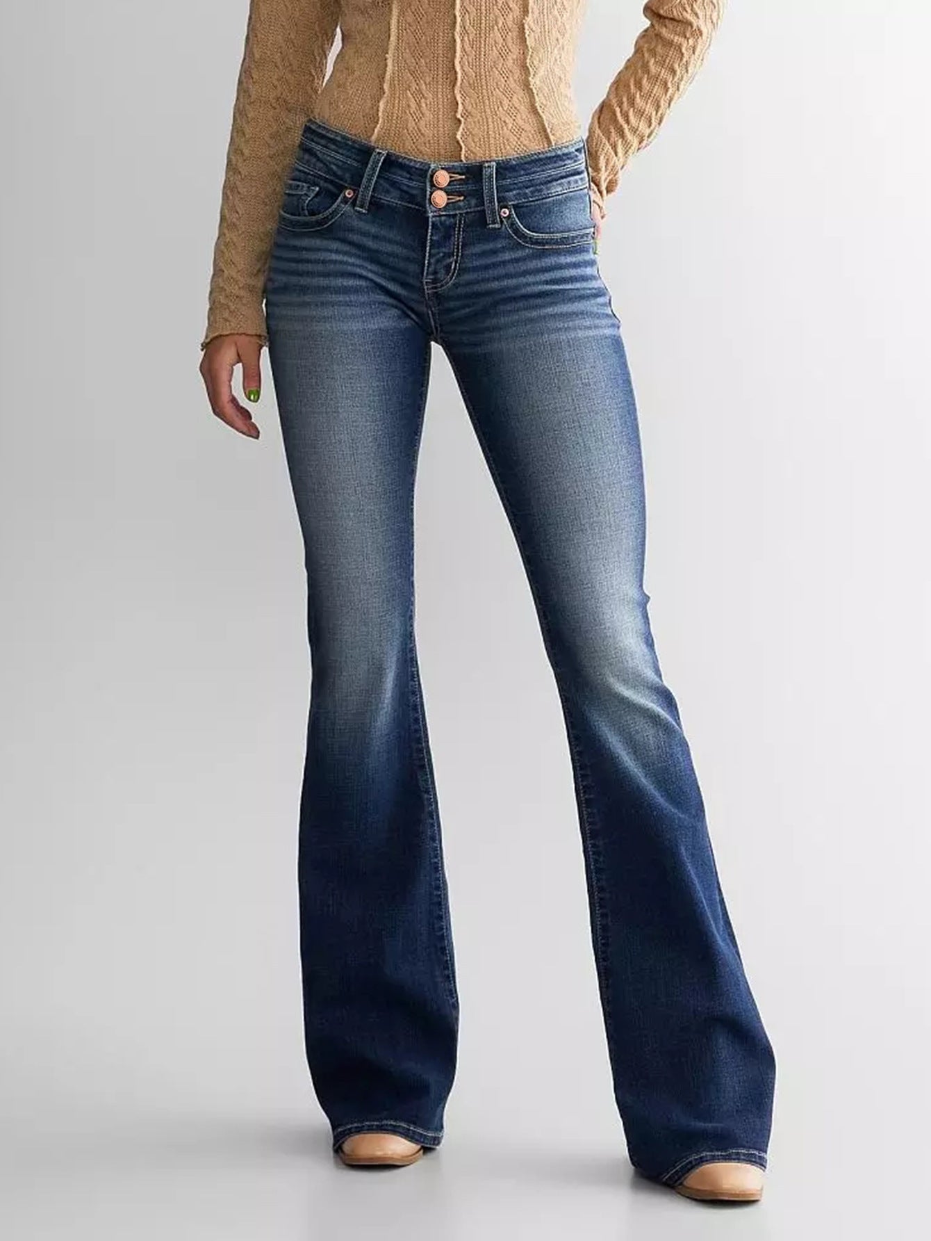 Woman wearing blue mid waist slim fit flared jeans on a light gray background – JeansSpot