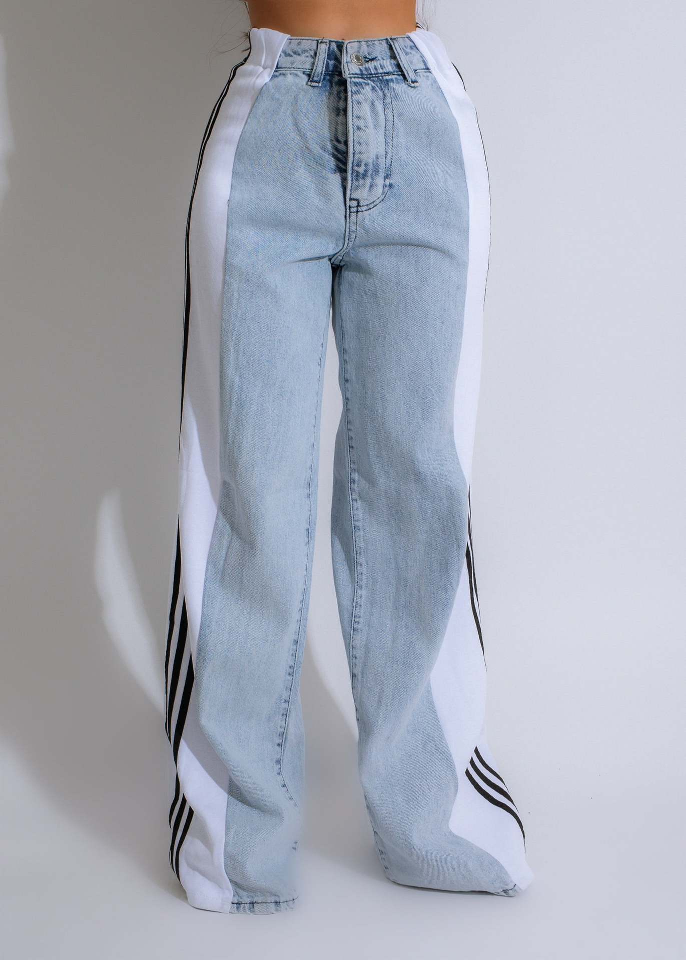 Light blue jeans with white and black stripes on a plain background