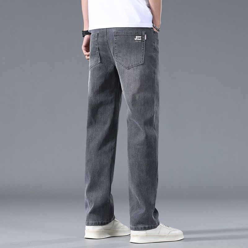 Person wearing gray jeans on a gray background